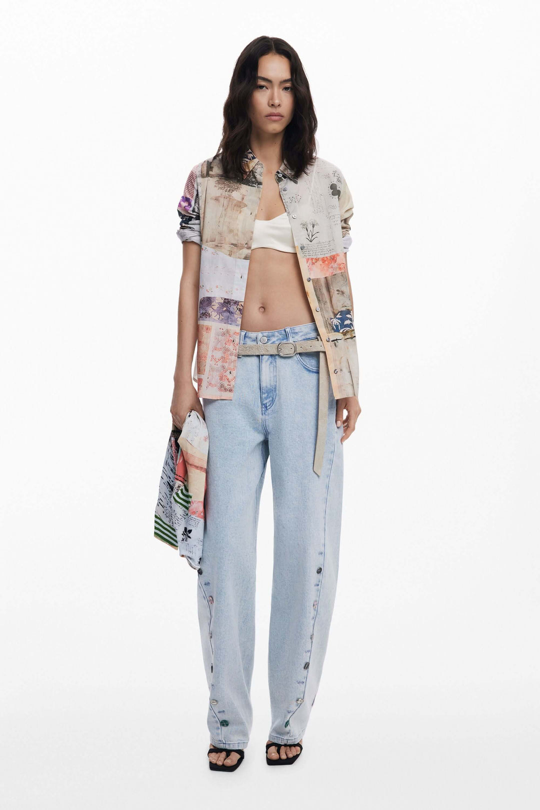 Chemise à manches longues imprimée vintage, portée avec un pantalon bleu clair, pour un look audacieux et créatif.