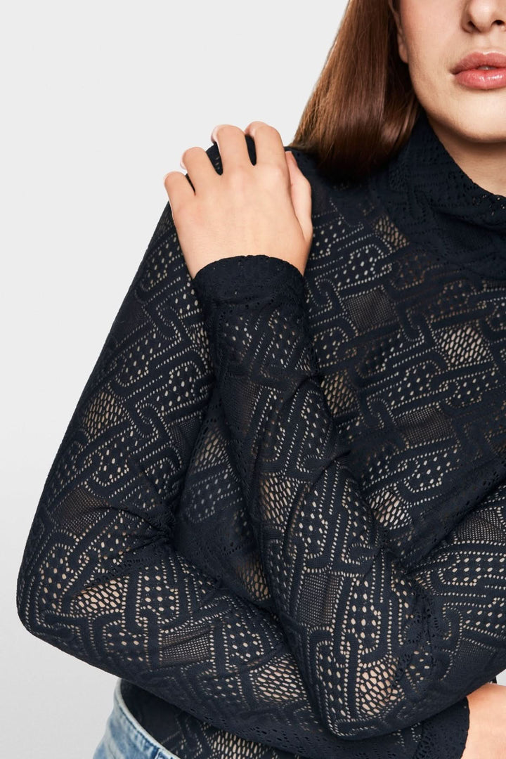 Haut en dentelle noir à manches longues, coupe ajustée et col montant pour un look moderne et féminin.