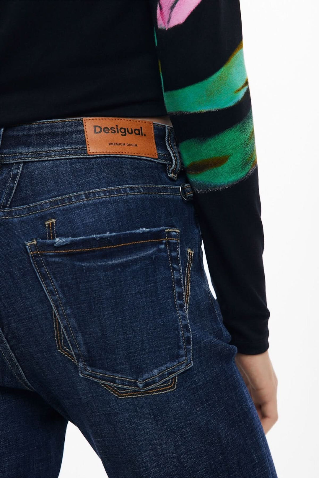 Vue arrière d'un jean évasé Desigual avec détails usés et étiquette en cuir.
