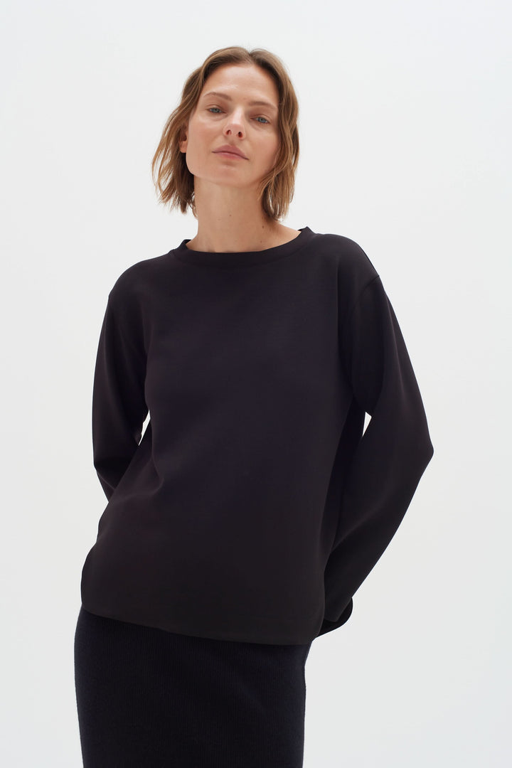 Chandail Gincent noir à manches longues, col bateau, silhouette minimaliste pour un style élégant et confortable.
