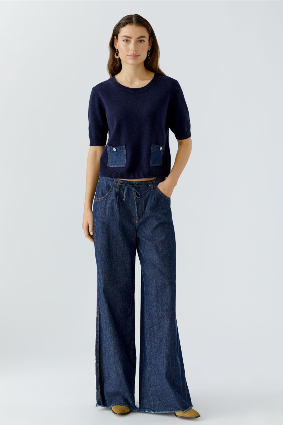 Femme portant un jean ultra léger à coupe large et un haut cintré avec poches avant.
