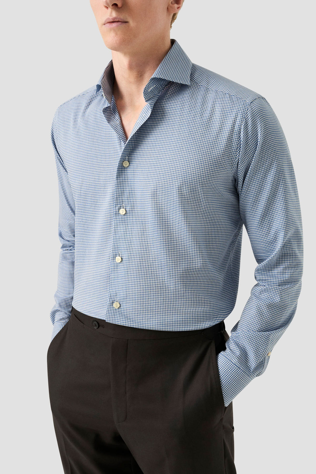 Chemise habillée à motifs carreaux fins, col classique ouvert, coupe ajustée, portée avec pantalon noir.