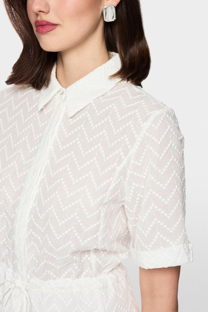 Femme portant une robe en coton avec cordon, manches courtes avec revers et col chemise classique pour un look élégant.