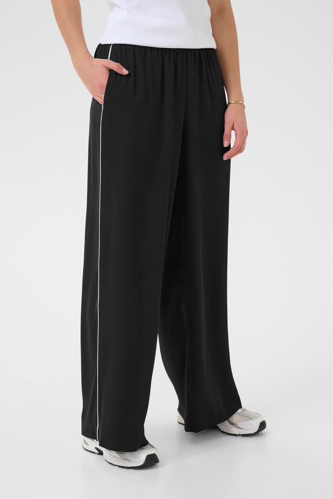 Pantalon fluide Tessa en noir, taille élastique, jambe large, idéal pour un look décontracté.