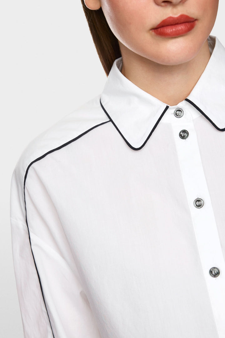 Chemise courte blanche avec col classique et détails contrastants, idéale pour un look moderne.