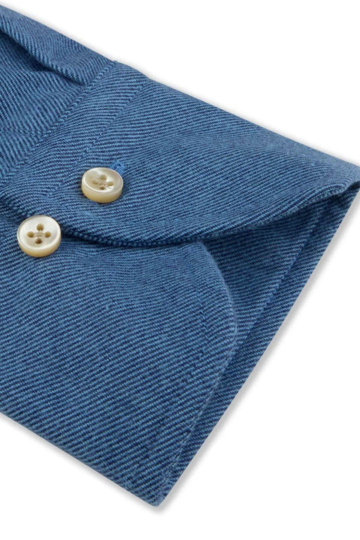 Cuff detail of blue chemise en flanelle coton à col boutonné with pearl buttons.