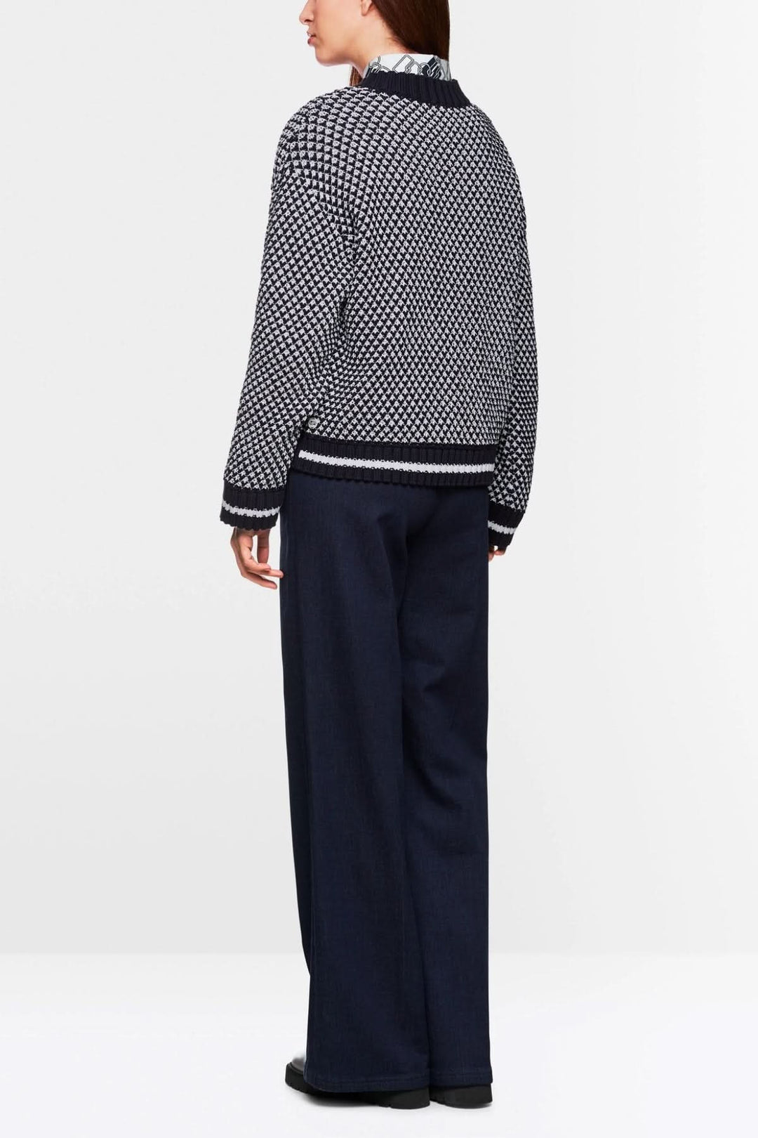 Chandail court tricoté à encolure en V, noir et blanc, porté avec un pantalon fluide, vue de dos.