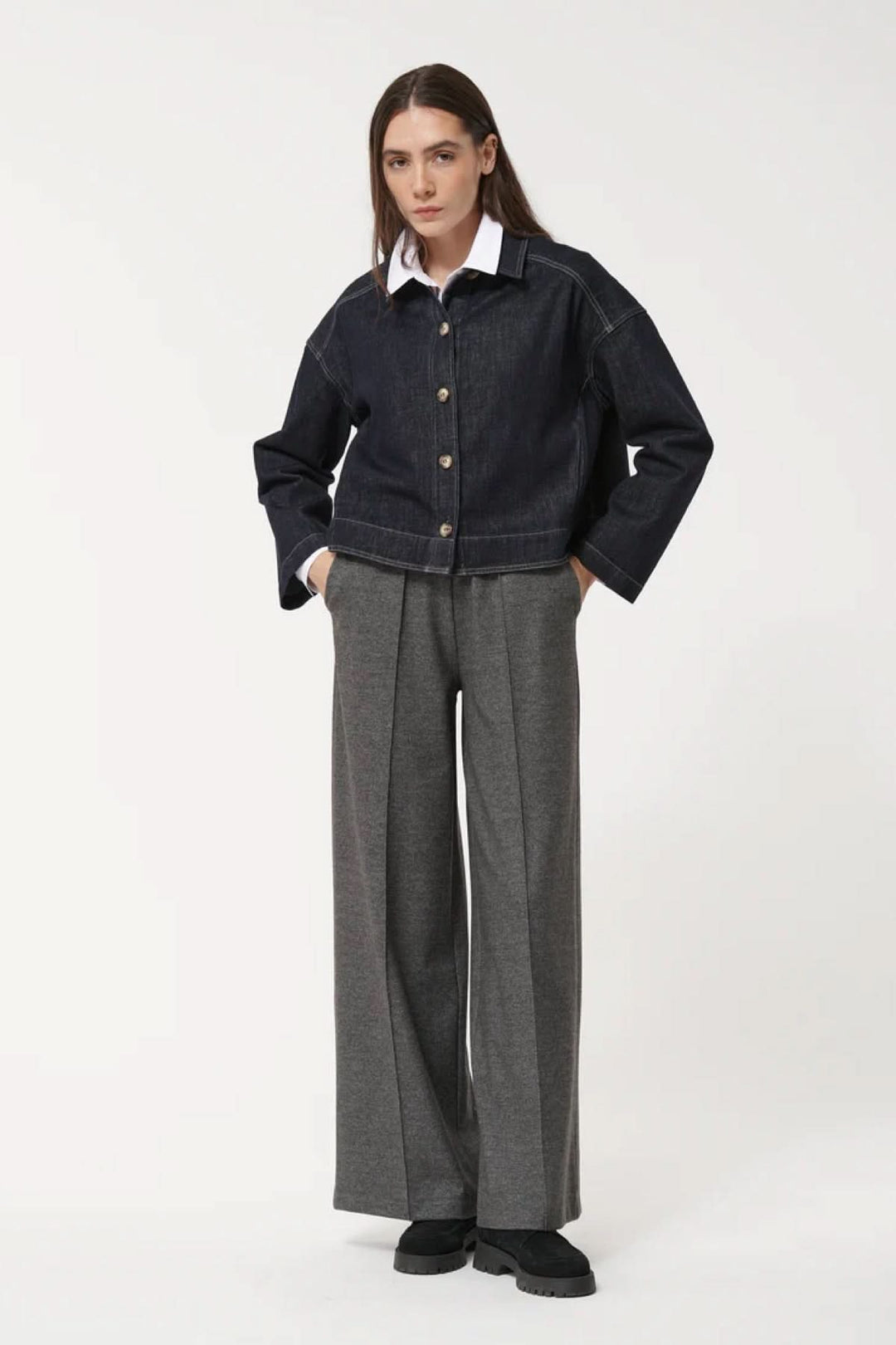 Modèle portant un pantalon ample à la coupe fluide avec taille élastiquée, plis marqués et poches latérales, pour une allure décontractée.