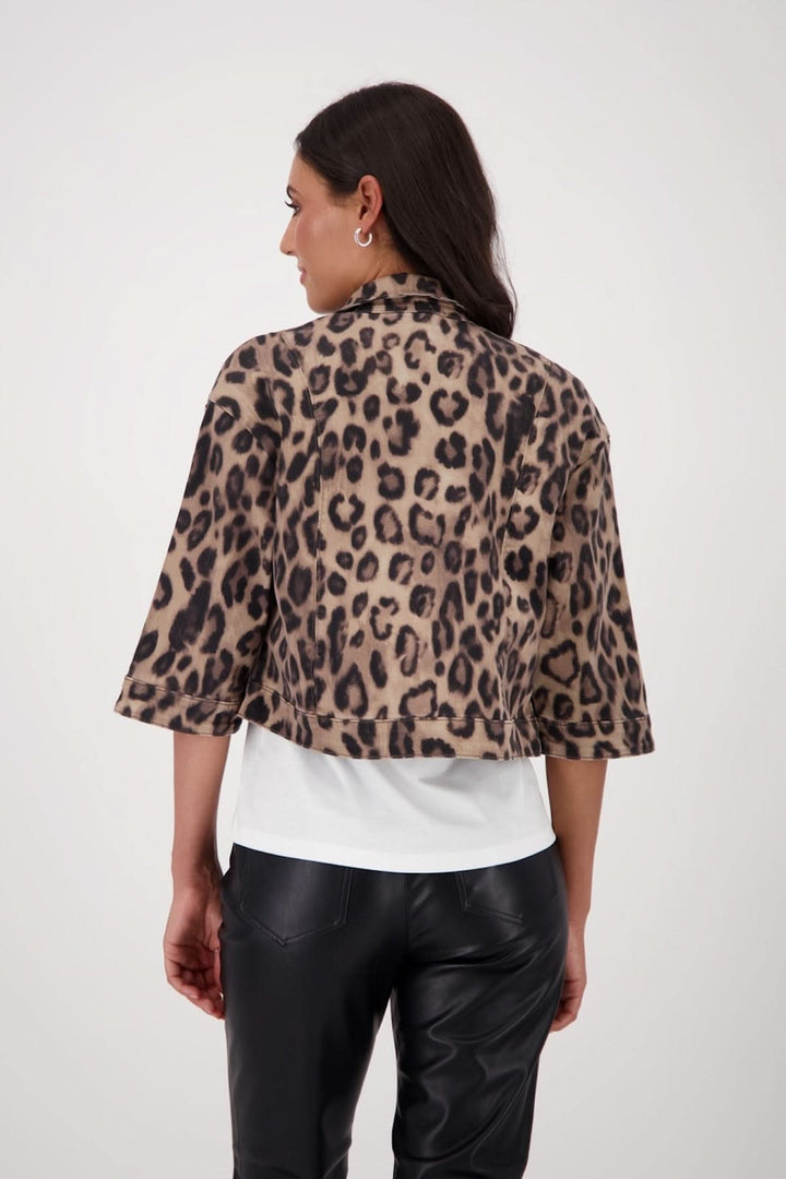 Veste courte à imprimé léopard, vue arrière, associée à un t-shirt blanc et un pantalon noir en simili cuir.