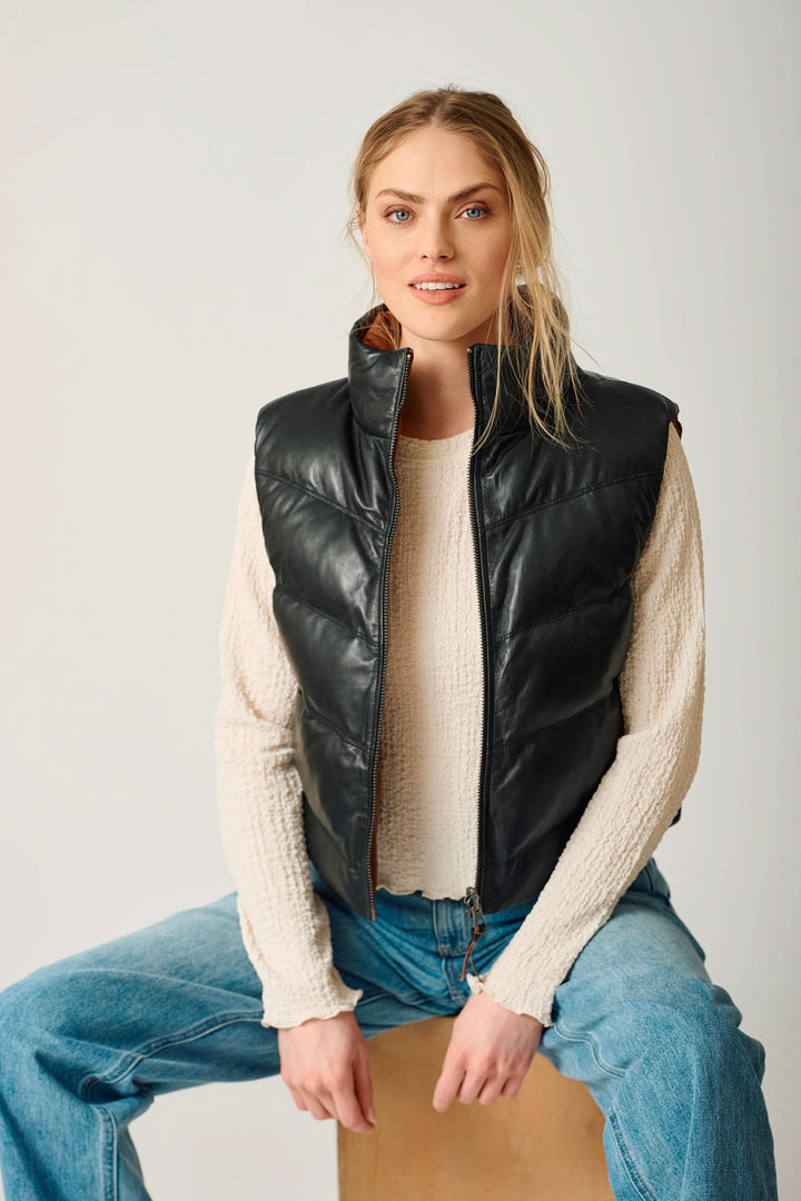Manteau réversible Ellen porté avec style, montrant le côté noir classique, coupe matelassée et col montant idéal pour la mi-saison.