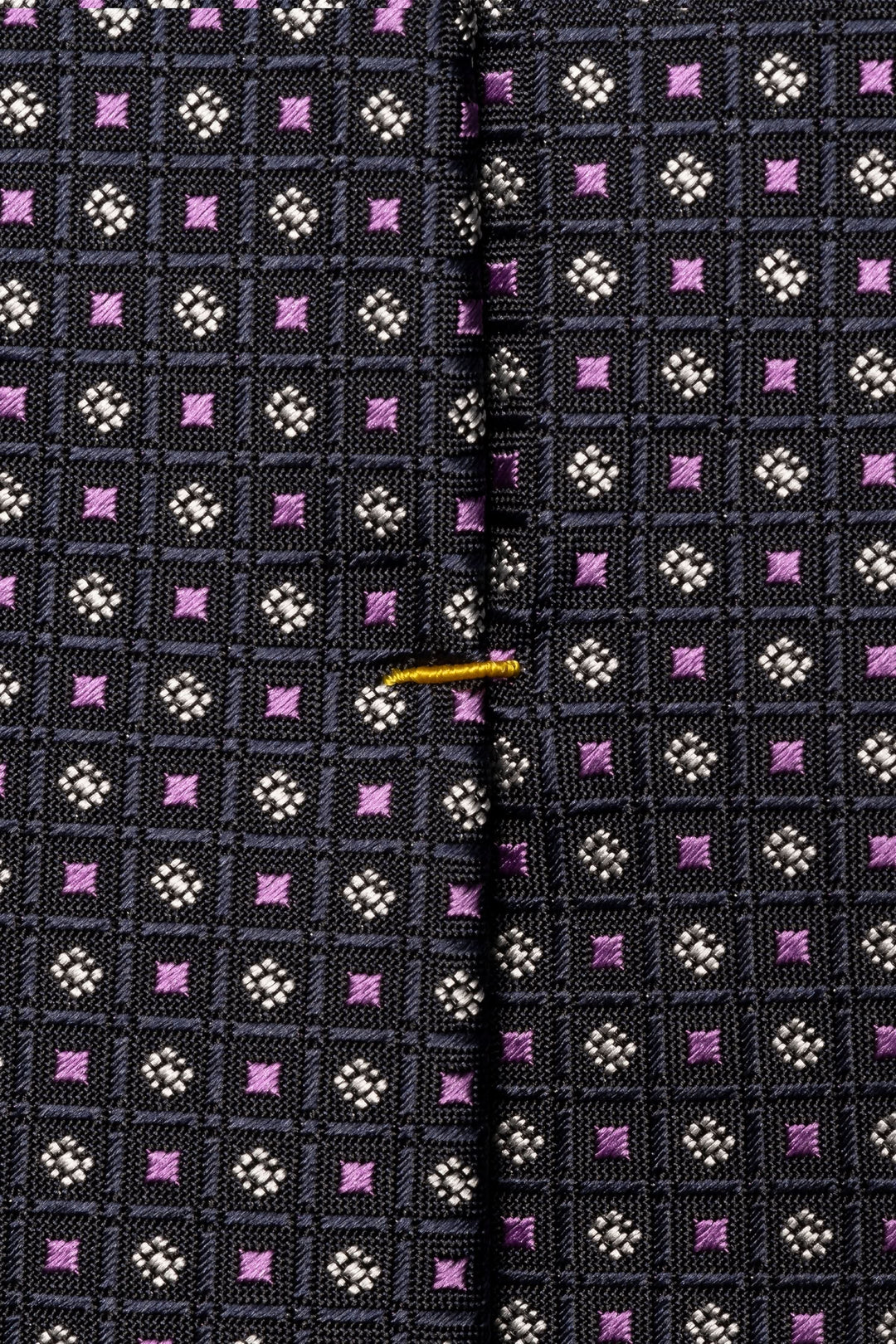 Cravate motif géométrique avec texture légèrement satinée et design à carreaux colorés.
