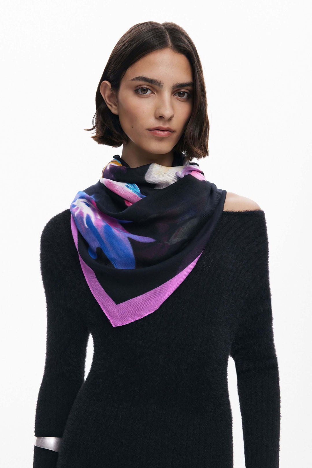 Foulard rectangulaire à fleurs avec imprimé floral coloré et liseré contrasté sur fond sombre, porté élégamment par une modèle.
