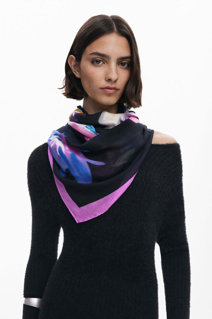 Foulard rectangulaire à fleurs avec imprimé floral coloré et liseré contrasté sur fond sombre, porté élégamment par une modèle.
