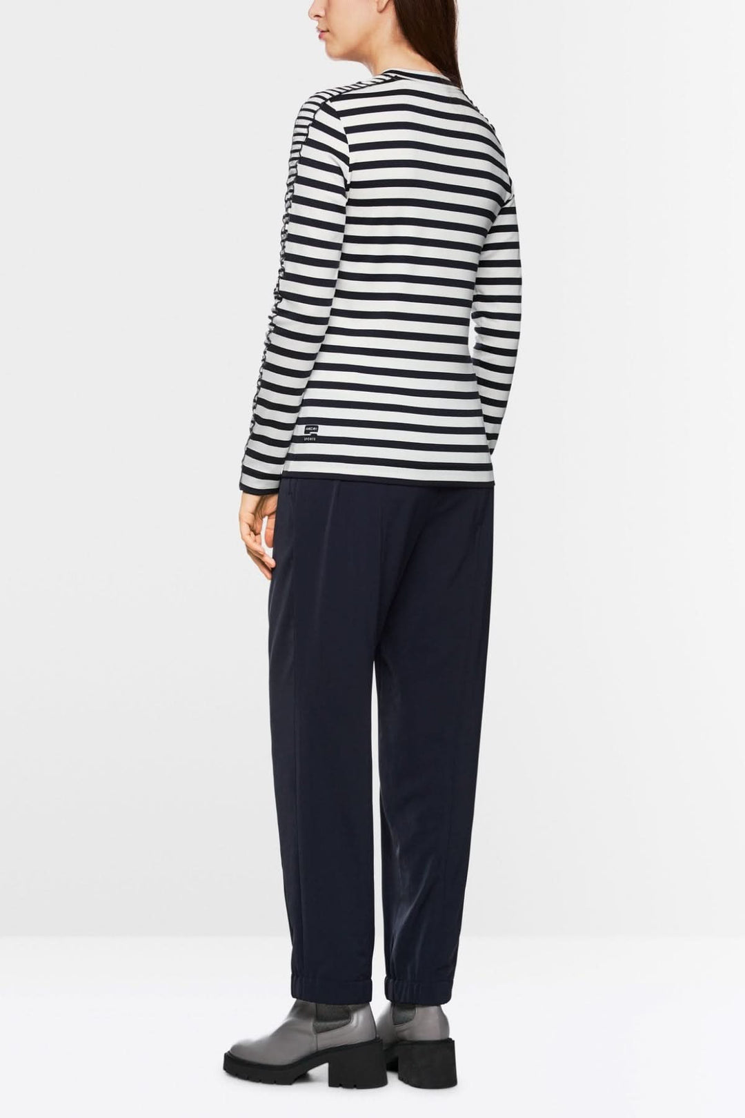 Femme portant un chandail à rayures maritimes avec mini-volants, vue arrière, style confortable et moderne.