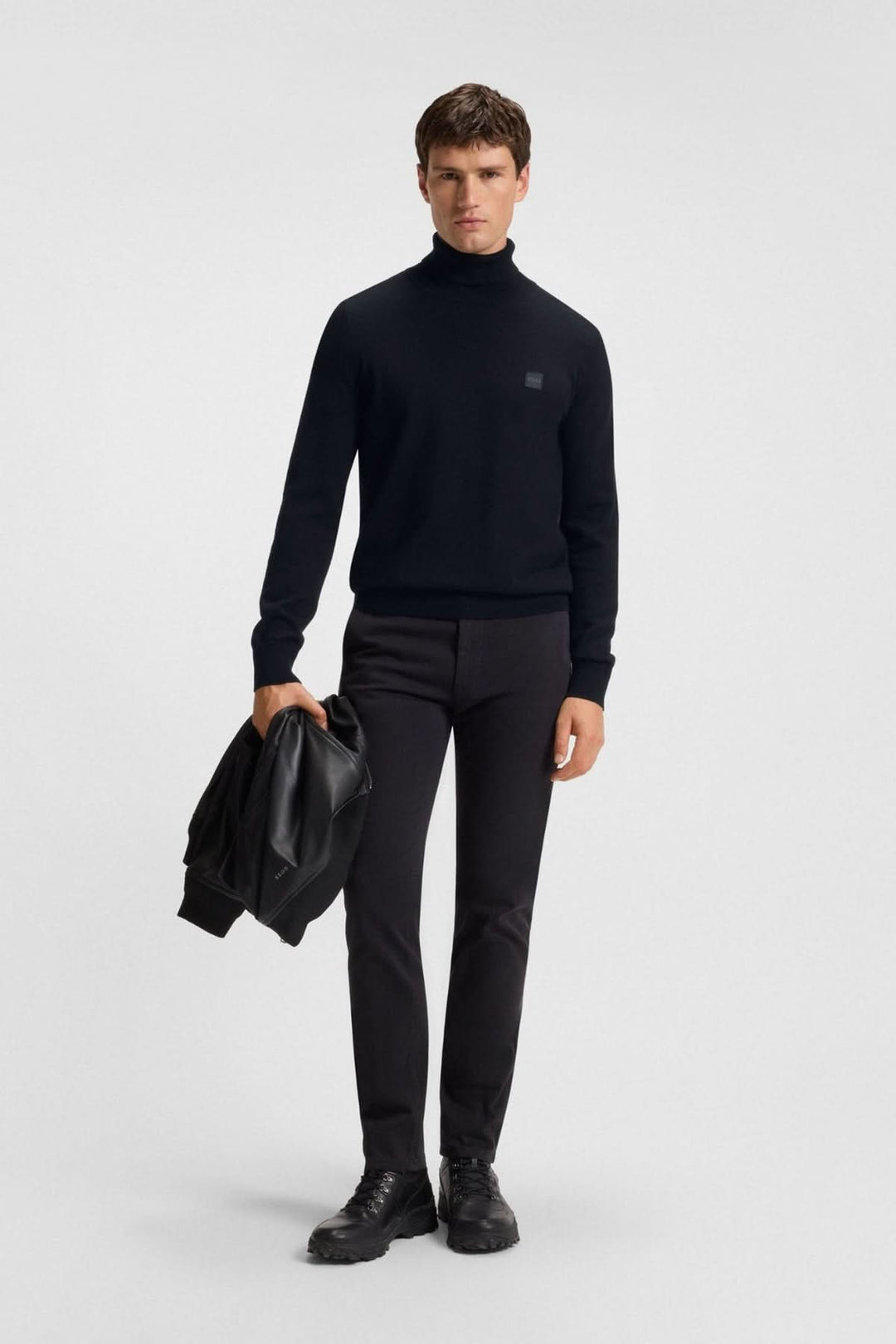 Homme portant col roulé coton et cachemire Boss Orange noir, allure moderne et élégante.