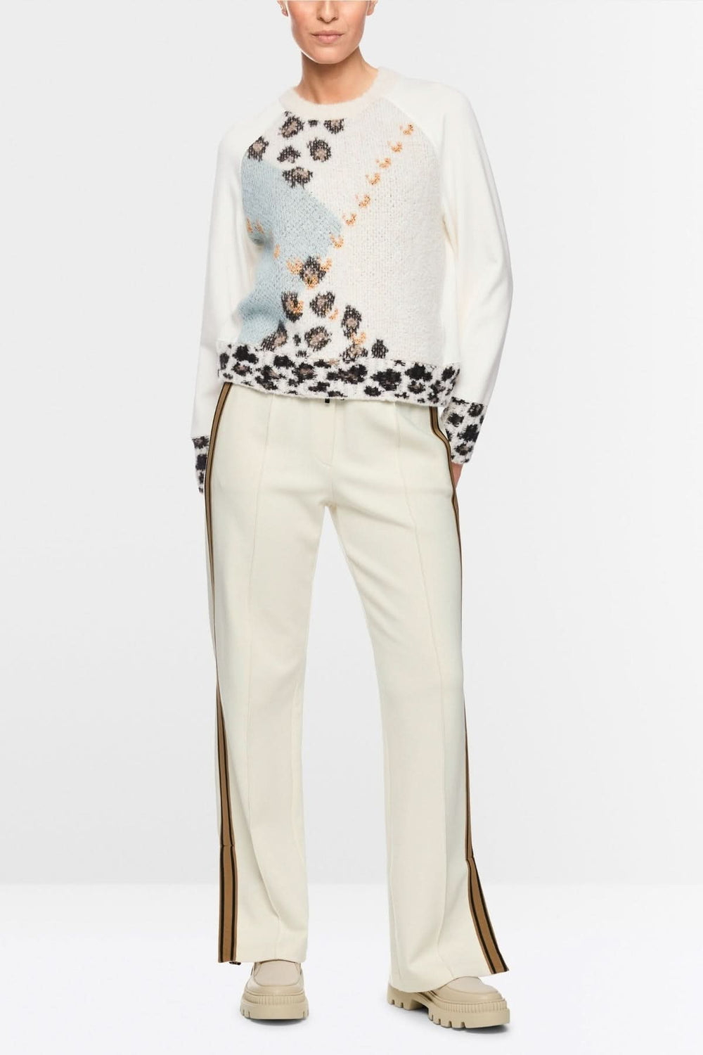 Chandail motif graphique avec empiècements tricotés et motifs inspirés par la nature, manches longues et design moderne.