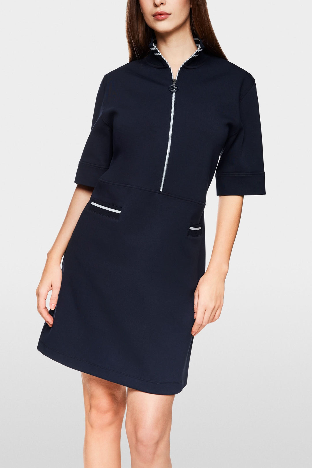 Robe courte sportive chic, col montant rayé, fermeture zippée, poches contrastantes.