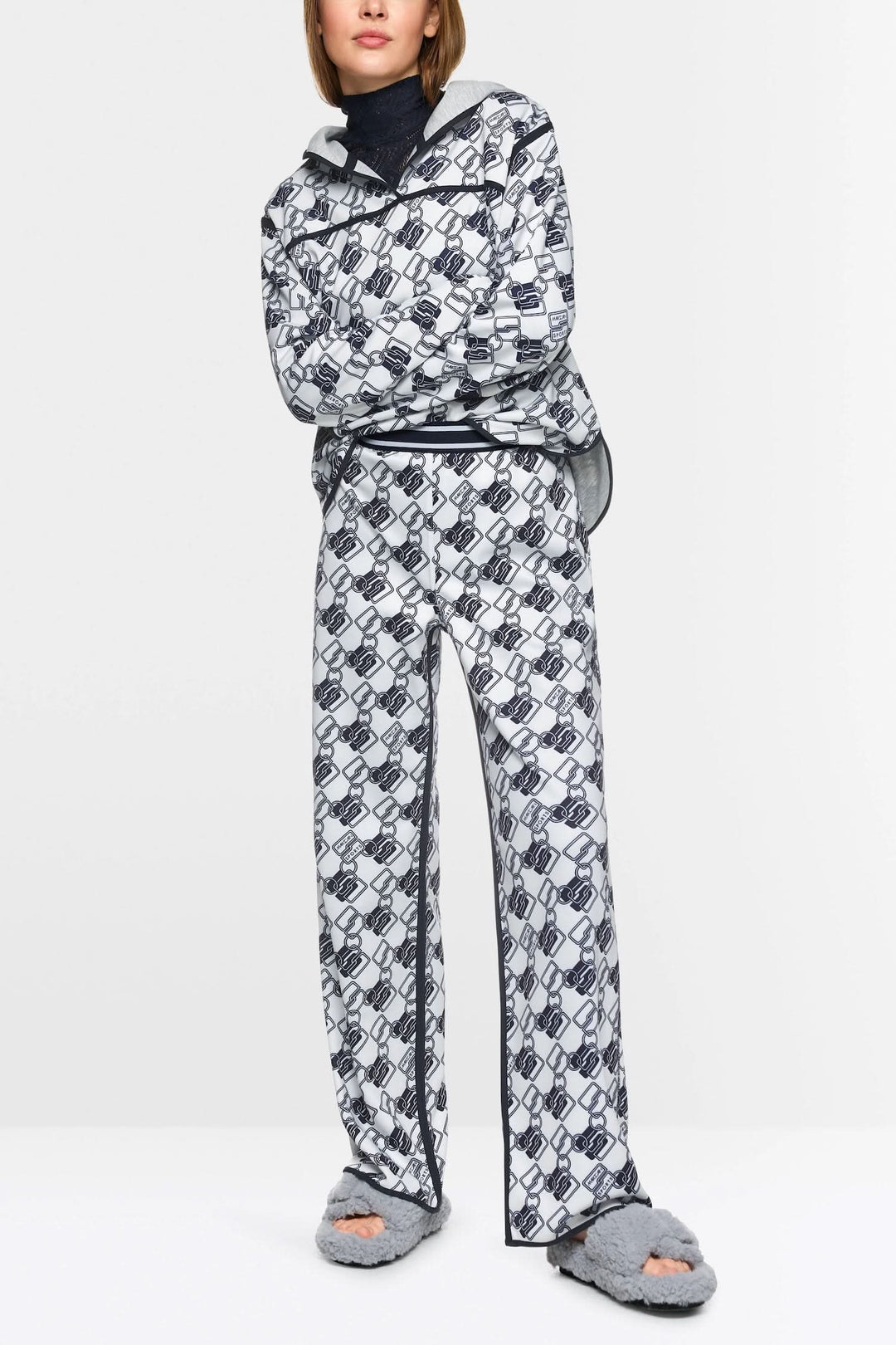 Chandail à capuche réversible avec motif géométrique moderne, porté avec un pantalon assorti.