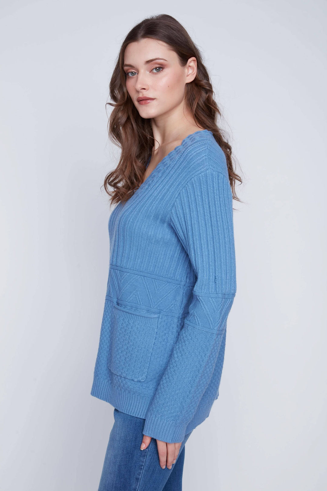 Tunique en tricot bleu à manches longues, encolure en V et poches devant, style décontracté.