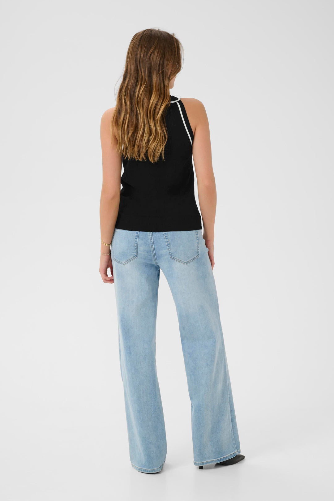 Camisole Lizza noir en tricot fin, vue dos avec jeans décontractés, combinaison contemporaine et féminine.