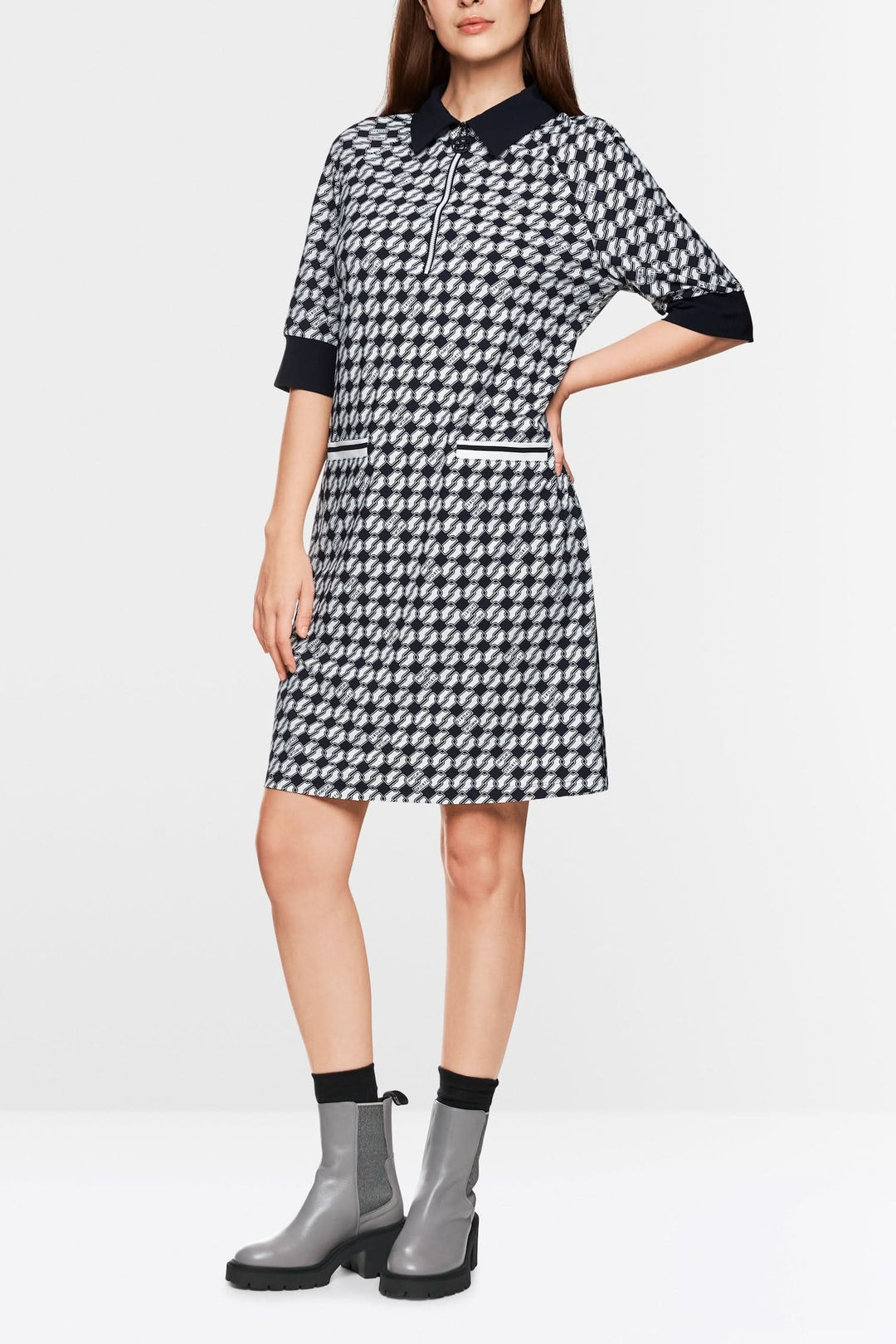 Robe en jersey scuba courte avec imprimé géométrique et bordures contrastantes, portée avec bottines grises.