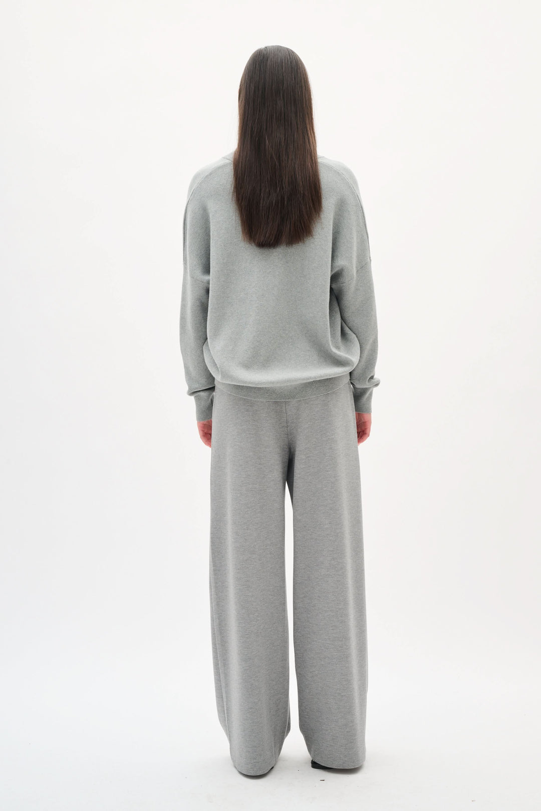 Chandail col en V Foster en coton, coupe décontractée, à l'arrière, porté avec un pantalon assorti gris.