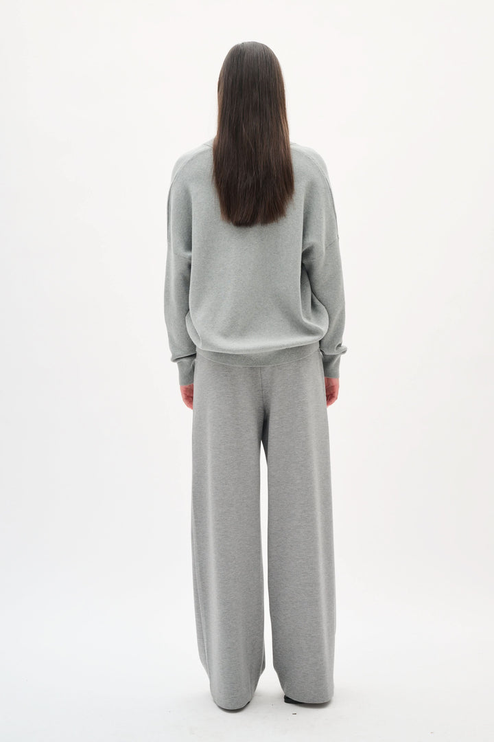 Chandail col en V Foster en coton, coupe décontractée, à l'arrière, porté avec un pantalon assorti gris.