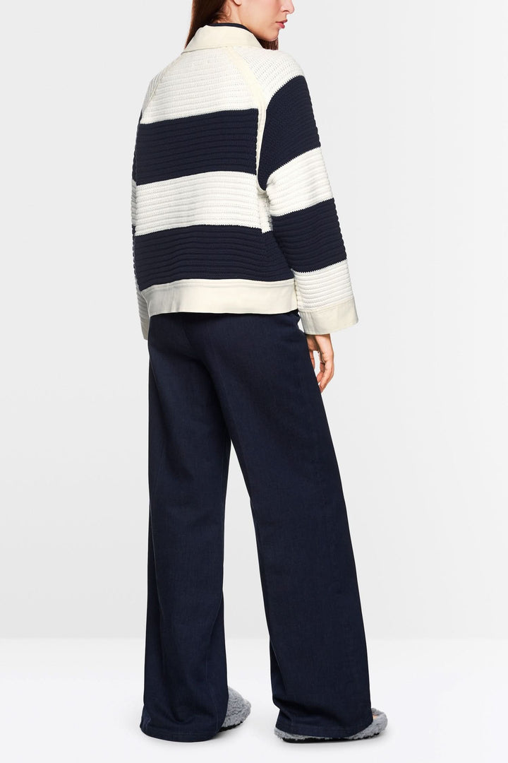 Cardigan court à blocs de couleur, silhouette ample, avec empiècements en denim, porté avec un pantalon décontracté.