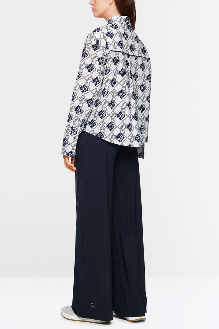 Chemise imprimée à motif chaînes, coupe droite, portée avec pantalon large marine.