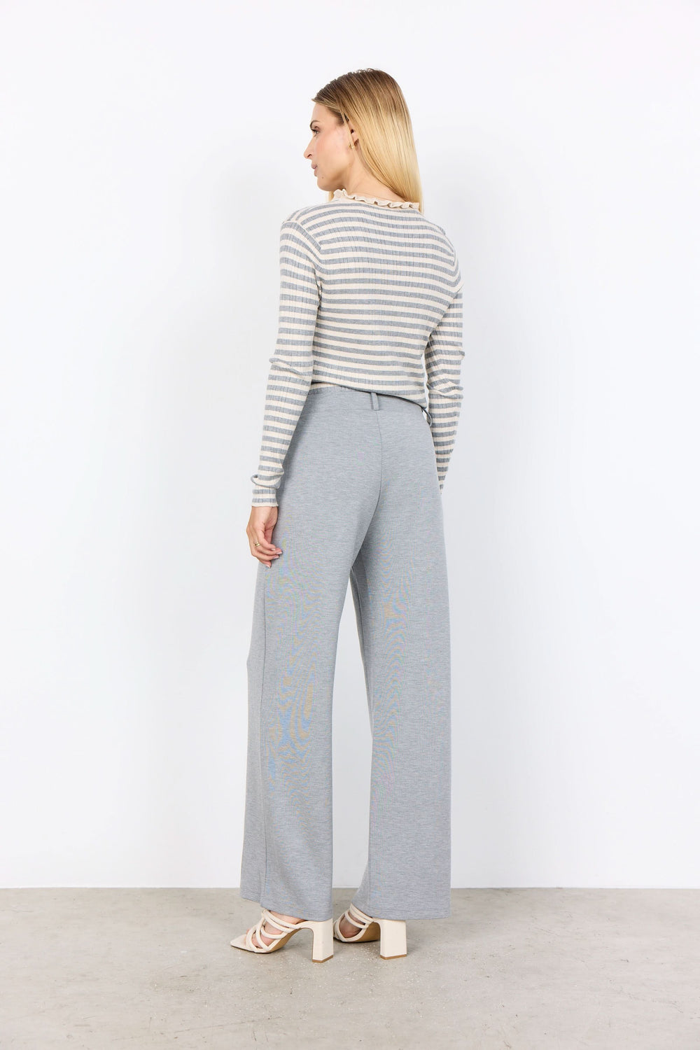 Chandail à rayures fines avec col festonné, porté avec pantalon gris ample, vue arrière.