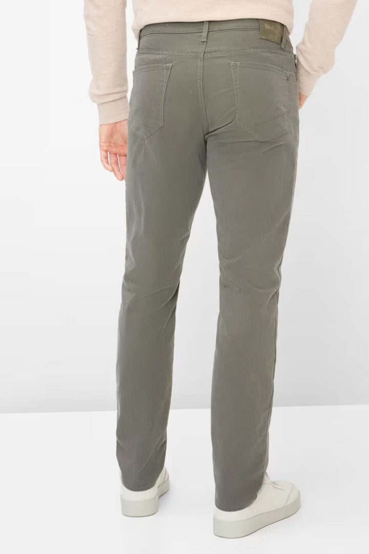 Homme portant un pantalon ajusté longueur cheville, vue de dos, coupe moderne et tissu confortable, couleur grise.