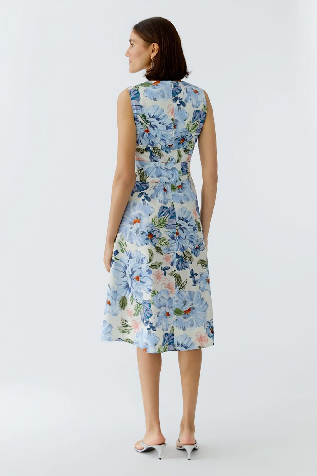 Femme portant une robe cintrée à imprimé floral vue de dos, élégante et féminine pour une occasion spéciale.