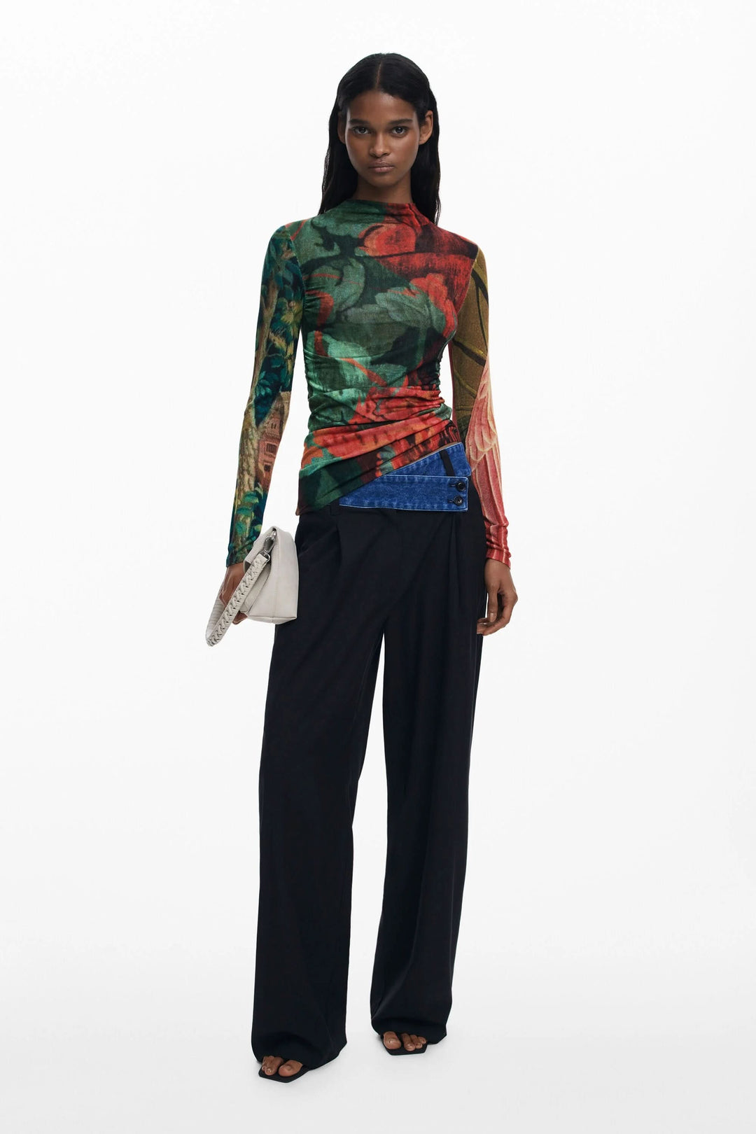 Chandail ajusté à col montant avec imprimé floral aux tons automnaux, porté avec un pantalon noir large.