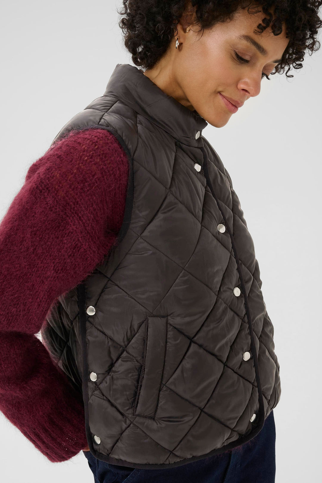 Manteau sans manches Sidse matelassé, coupe droite, porté sur un chandail épais.