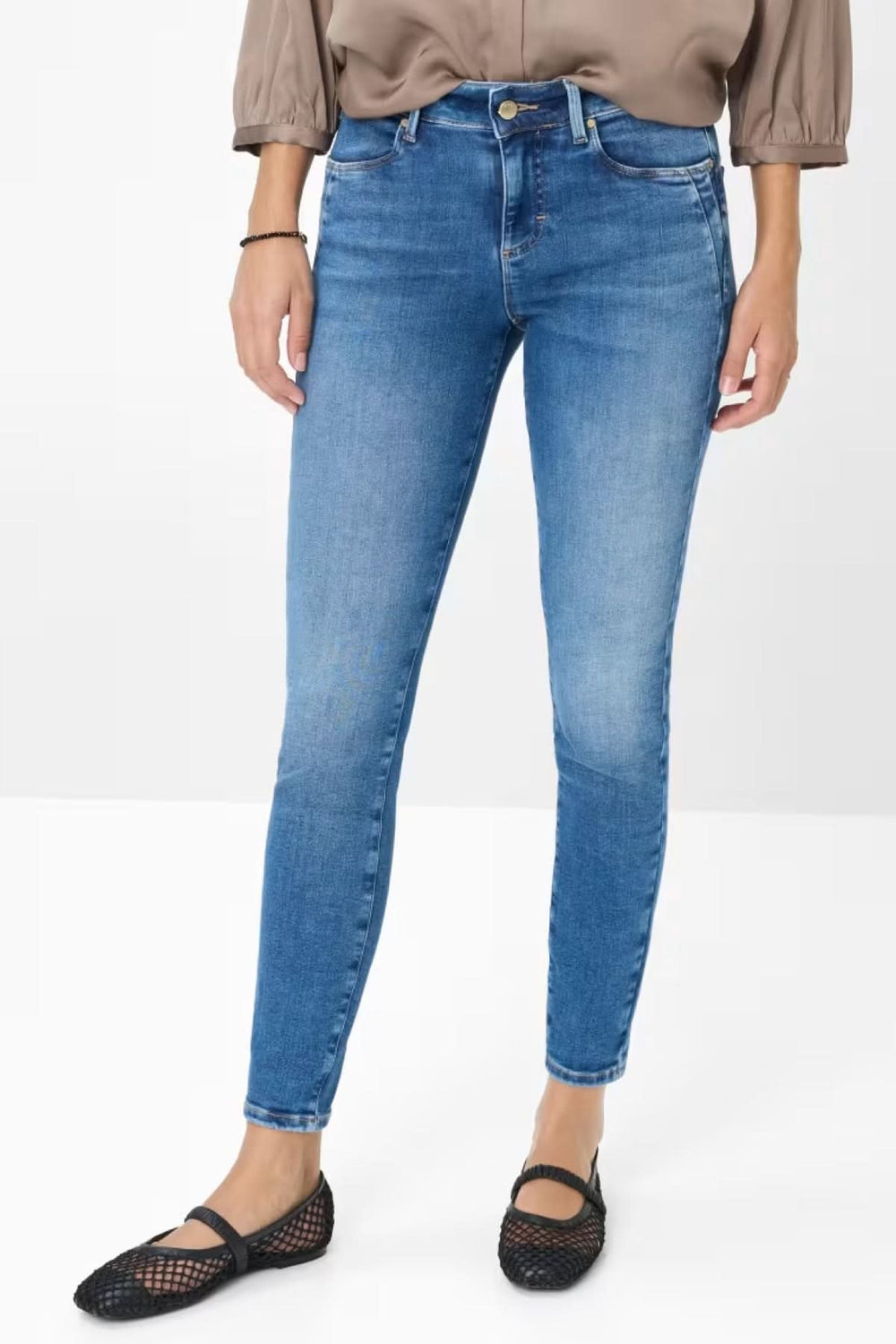 Jean skinny Ana en denim bleu clair, ajusté et mi-haute, porté avec un top fluide et des ballerines.