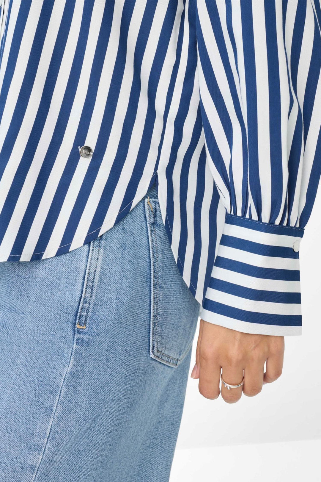 Blouse à rayures verticales bleu et blanc, coupe légèrement évasée, manches à poignets larges.