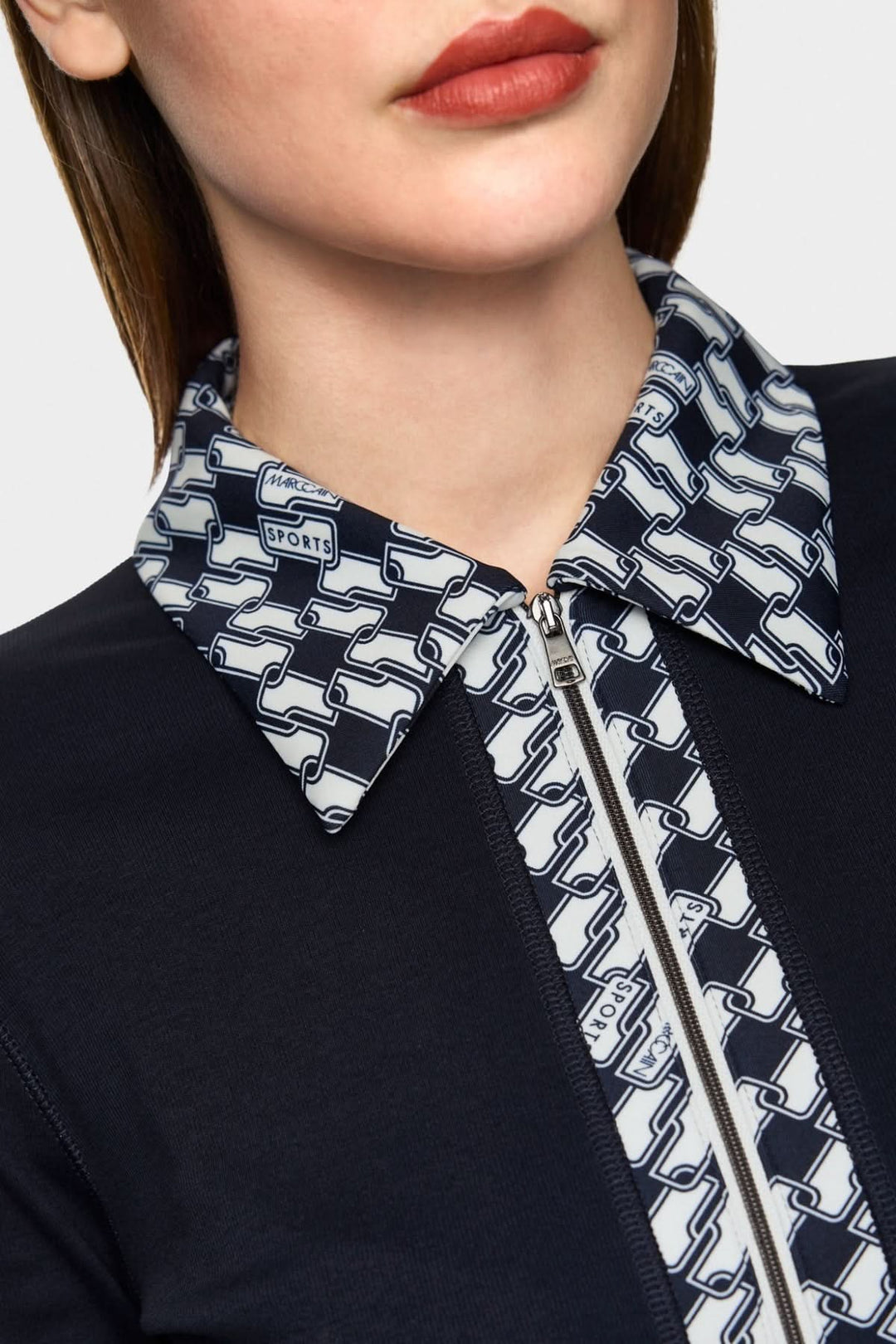Détail d'une veste en jersey avec un col graphique en cubes et fermeture éclair.