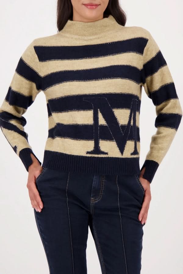 Femme portant un chandail à rayures avec col montant et détails jacquard, style moderne et confortable.