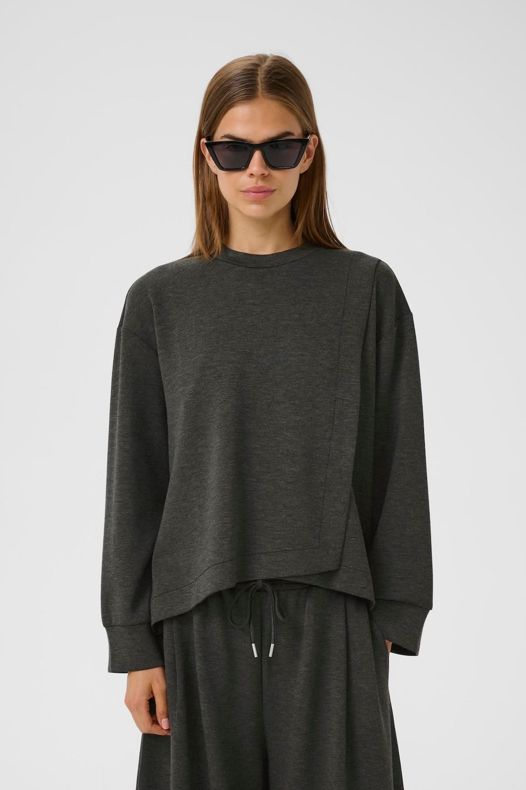 Chandail minimaliste à emmanchures tombantes, coupe contemporaine, avec surpiqûre asymétrique, idéal pour tenues détentes.
