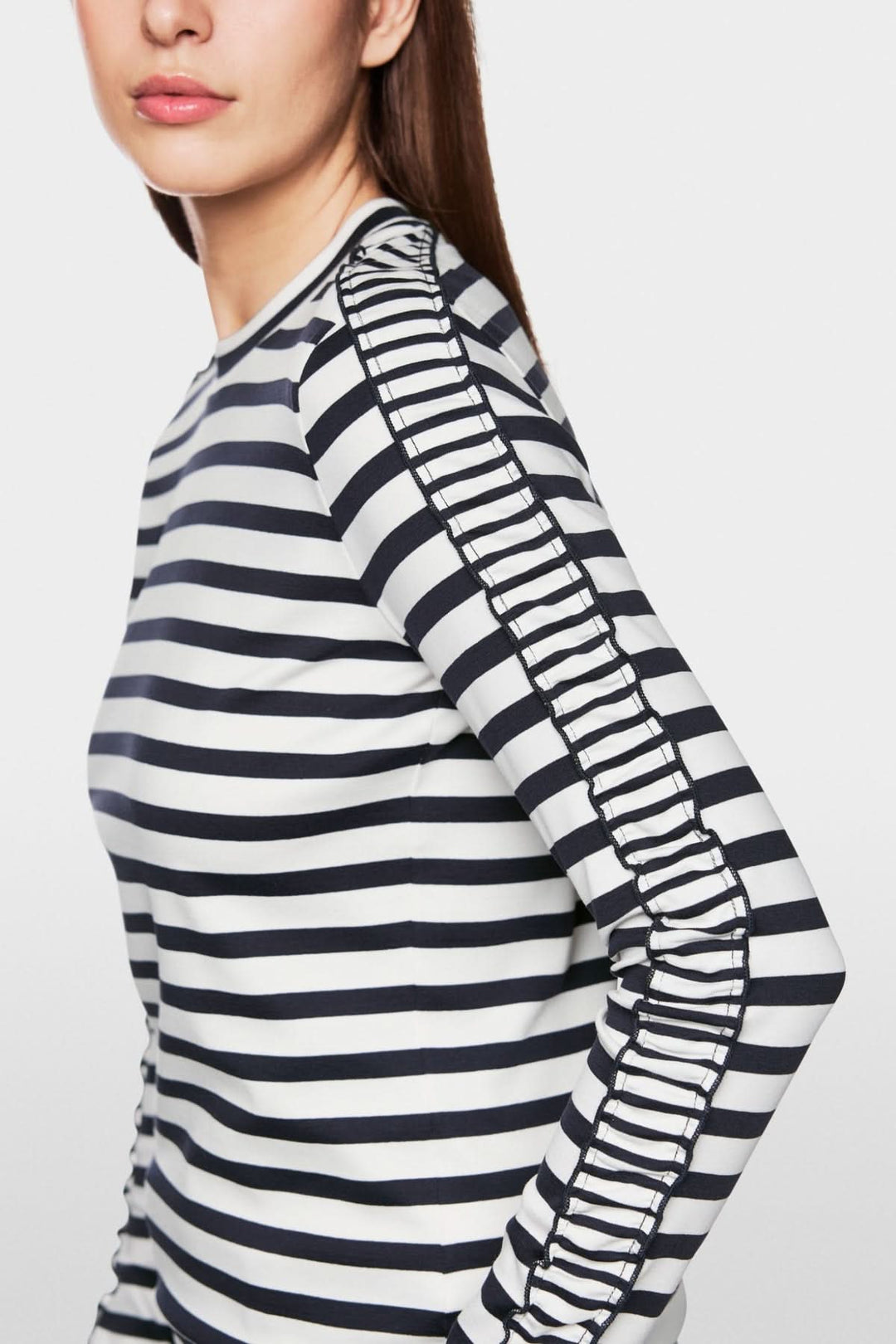 Chandail à rayures maritimes avec mini-volants sur les manches, offrant un style moderne et féminin.