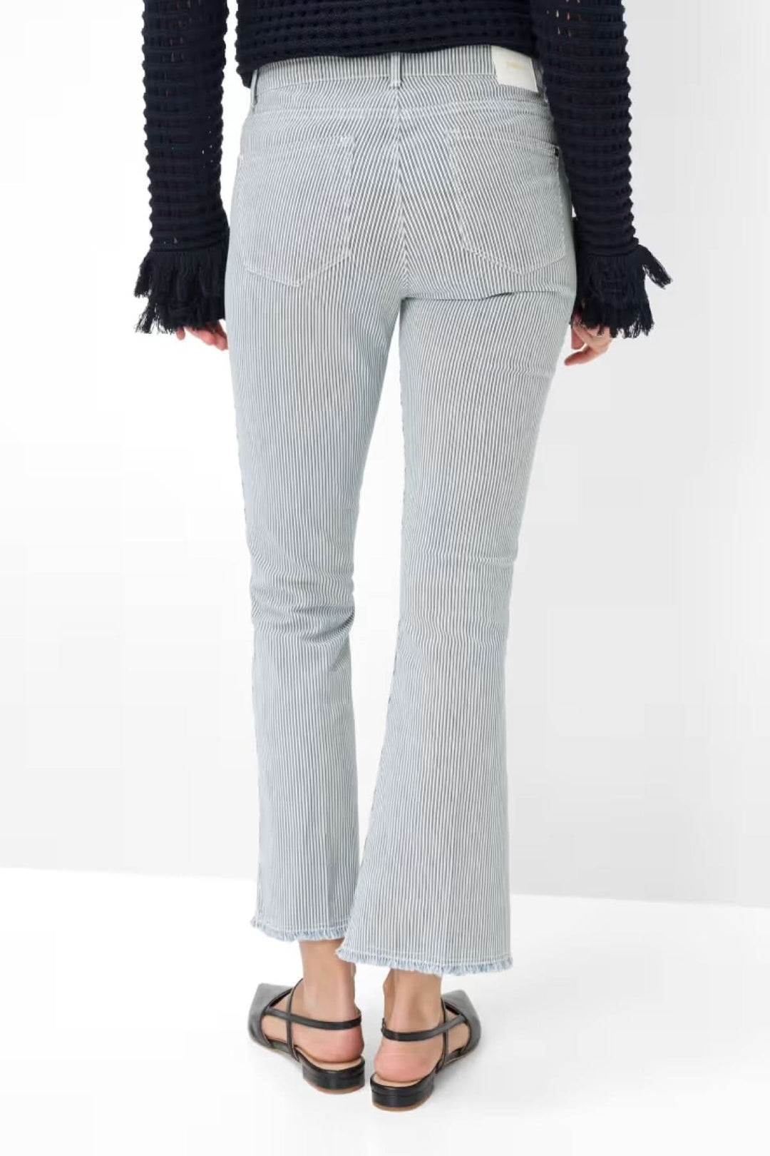 Vue arrière du Jeans SHAKIRA avec coupe ajustée et bas évasé, motif à fines rayures, porté avec un pull noir et sandales.