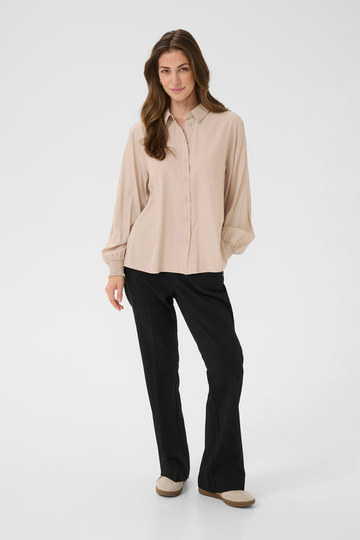 Blouse Nola fluide à poignets smockés, une pièce élégante et confortable pour tenues de travail et looks de week-end.