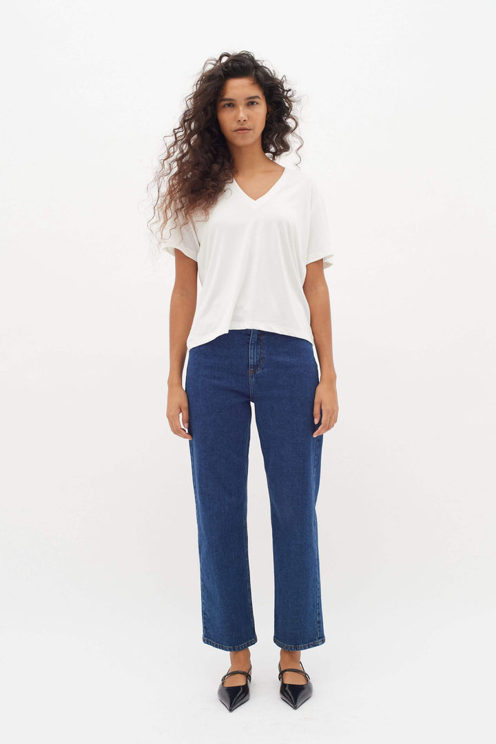 Femme portant un T-shirt col en V Liliana blanc, coupe droite et confortable, modernité et élégance pour un style quotidien.