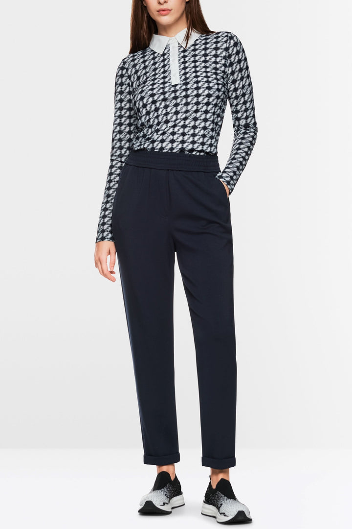 Femme portant un pantalon jogger Rhodos, taille haute et coupe droite, avec un haut ajusté à motifs.