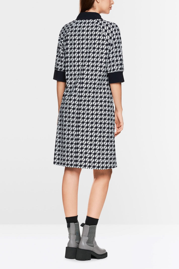 Robe en jersey scuba à imprimé géométrique, dos, portée avec des bottines grises.