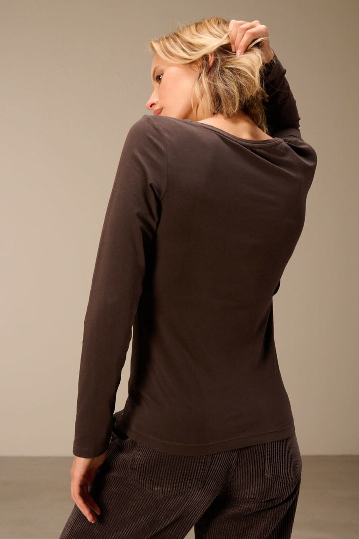 Femme portant un T-shirt manches longues col rond — jersey doux extensible vu de dos.