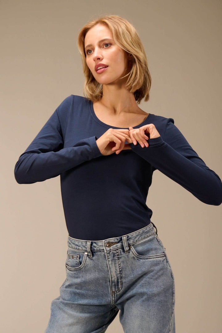 T-shirt manches longues col rond — jersey doux extensible porté par une femme avec jean pour un look net et polyvalent