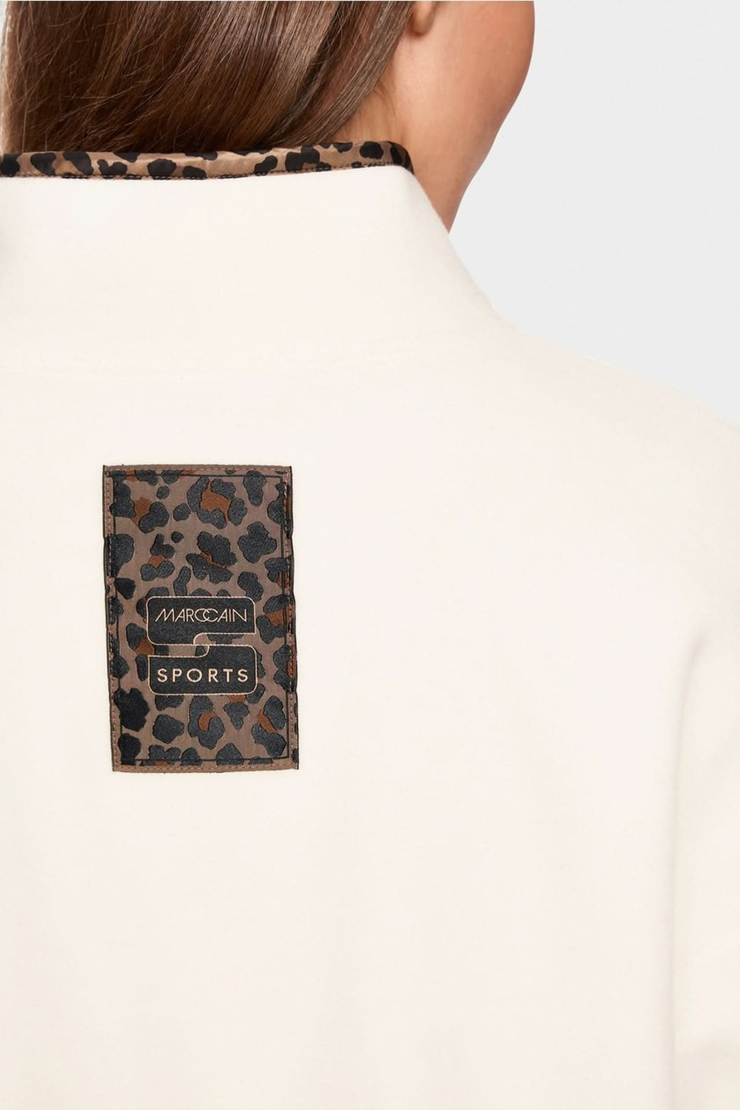 Arrière d'un chandail col montant avec étiquette léopard et détails contrastés pour un look tendance et original.