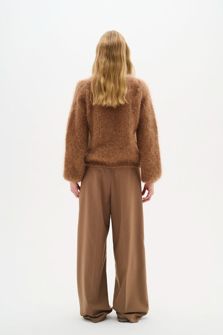 Chandail Jetra en maille duveteuse avec encolure ronde, porté avec un pantalon fluide marron.