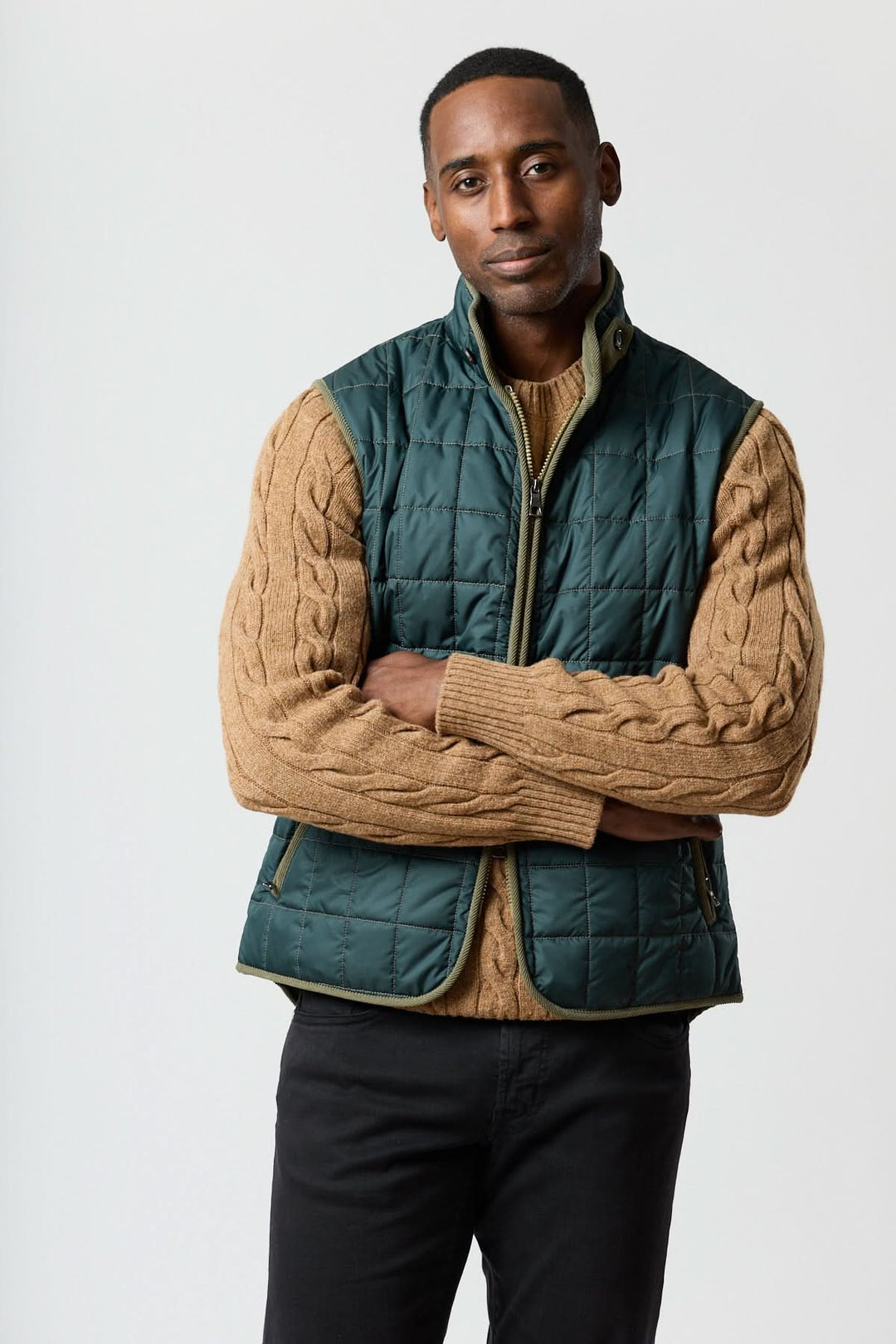 Veste sans manches matelassée avec détails en velours côtelé portée avec un pull marron, style élégant et pratique.